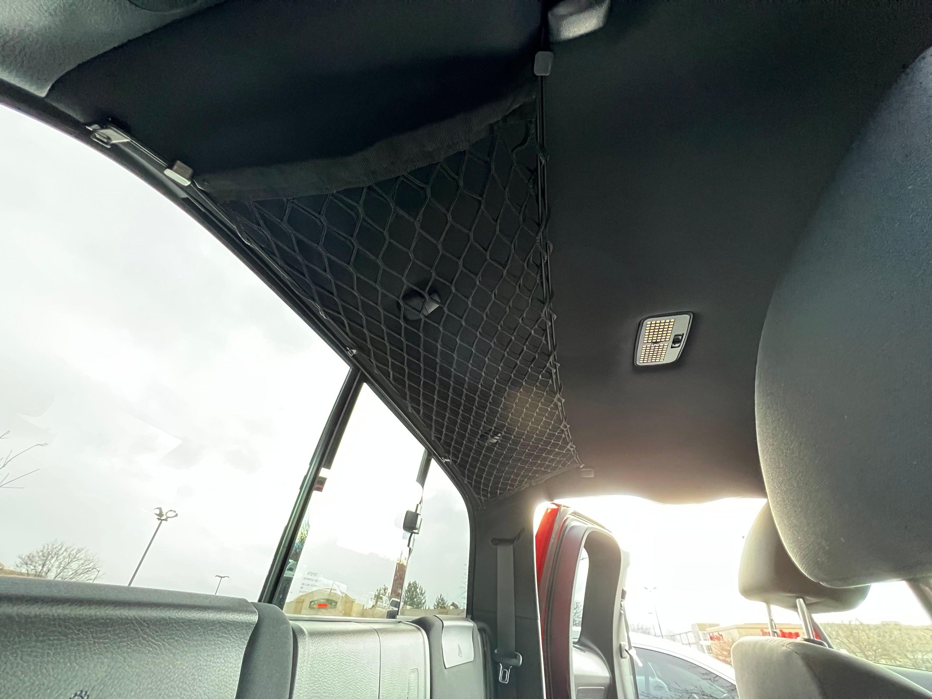 Toyota Tacoma attic storage net by Flatirons Overland, securely attached to vehicle interior for organized cargo space.