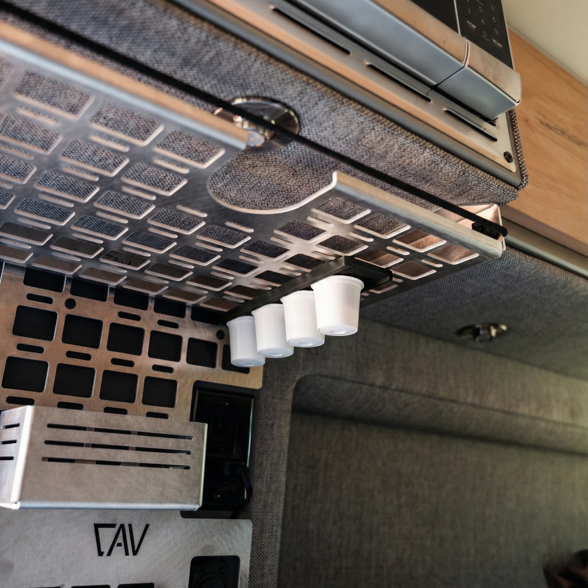 Canyon Keurig holder by Canyon Adventure Vans, made in Utah, shown in black with secure compartments for coffee accessories.
