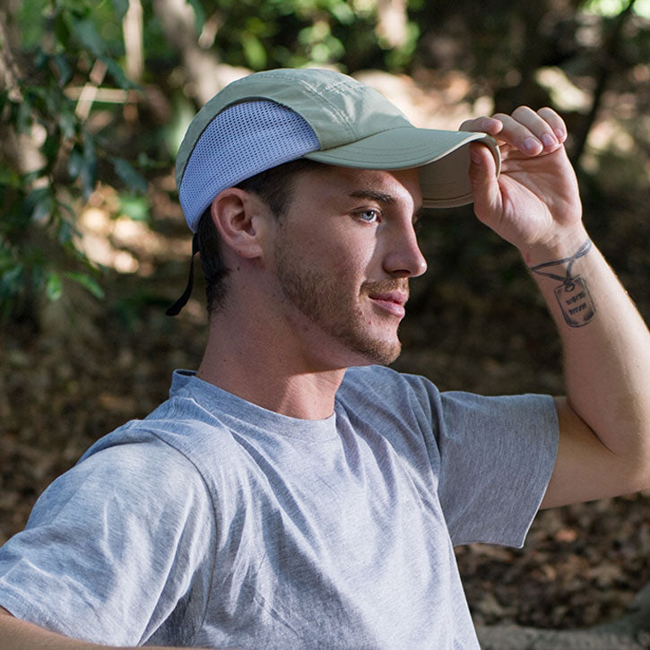 Juniper Outdoor Lair Cap in brown, featuring adjustable strap and breathable fabric, shown on a mannequin head.