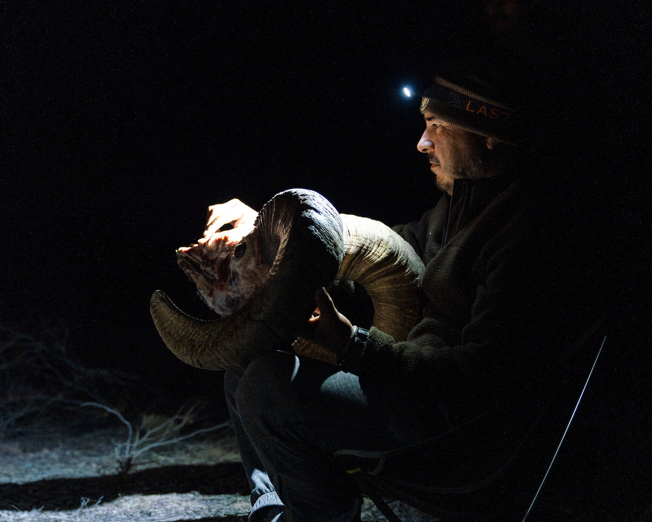 Last Light LLC Strike 1800 headlamp worn on a user's head, featuring adjustable straps and bright LED light for outdoor use.