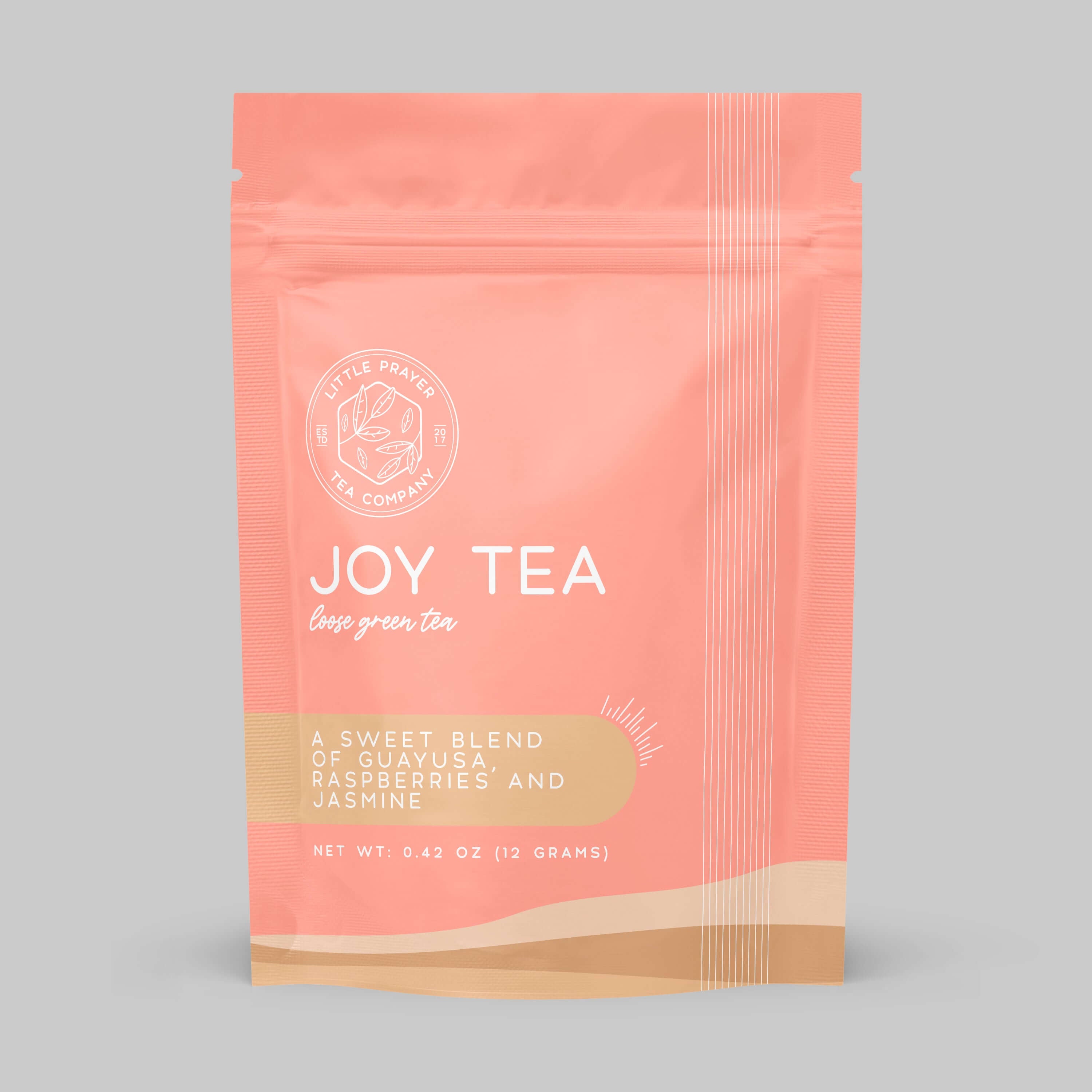 Assorted teas from around the world in colorful packaging, by Little Prayer Tea Company, displayed on a wooden surface.