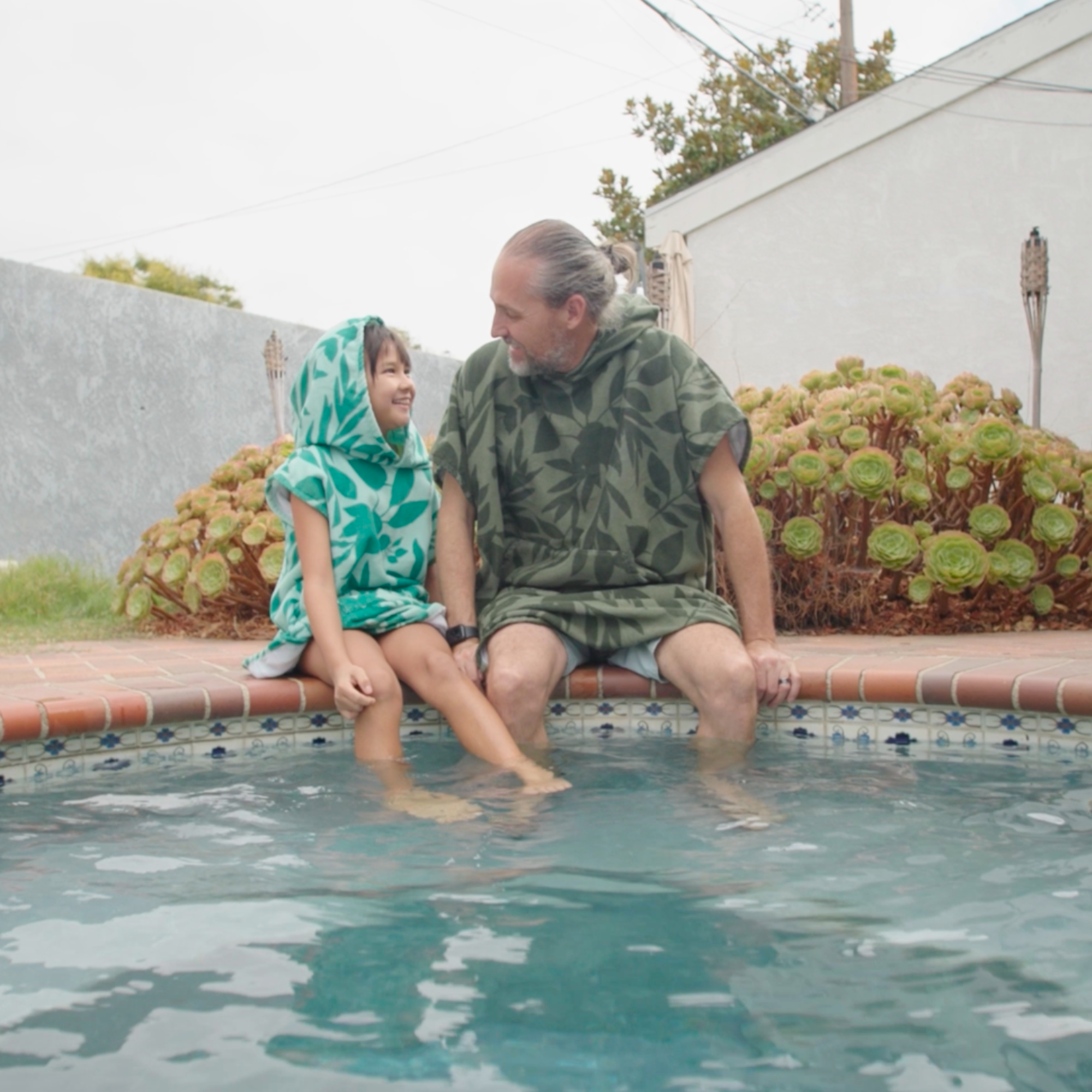 Kids Kailua Changing Towel Poncho by COR Surf, featuring a colorful Kona Kailua design, made of soft, absorbent fabric for beach use.