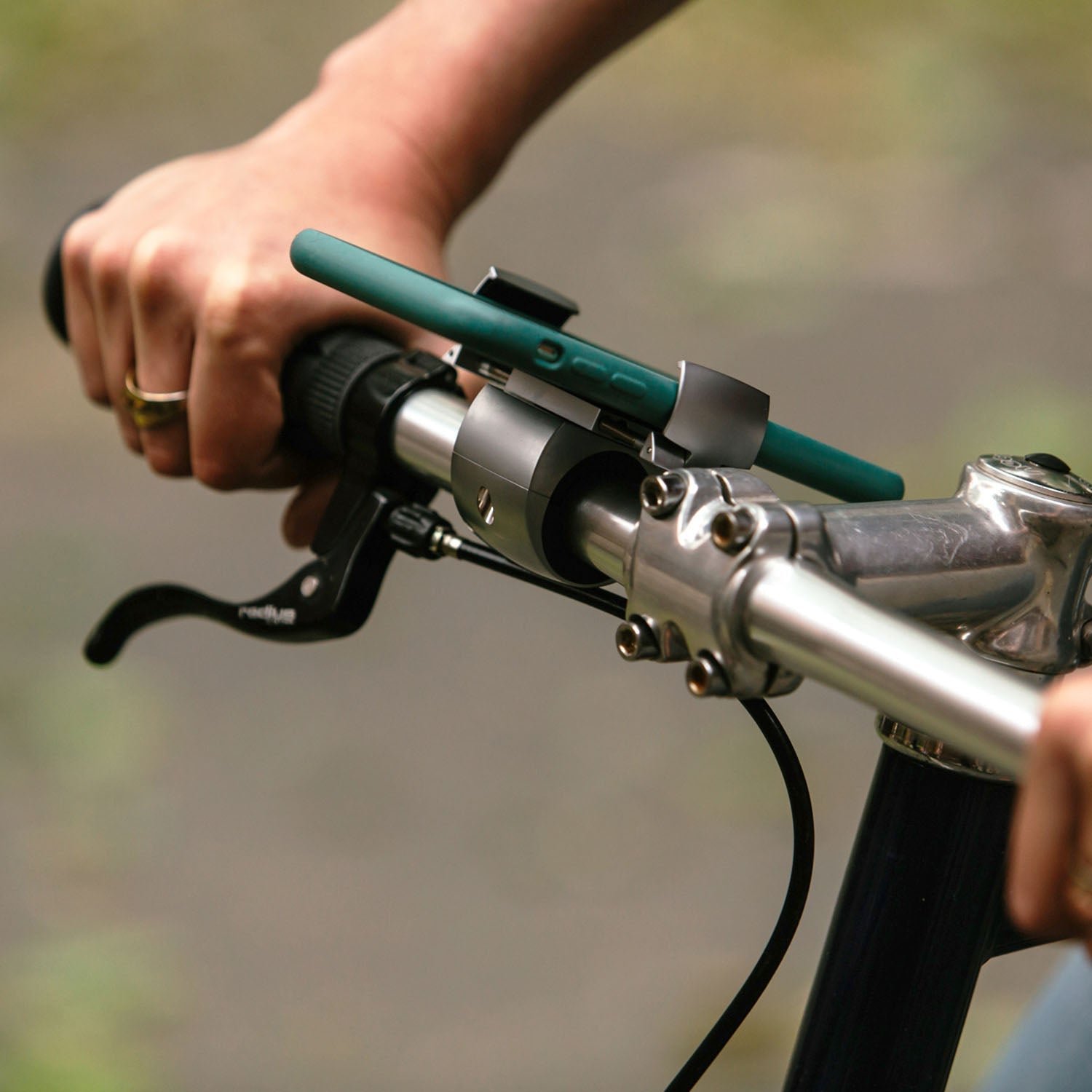 ZEITBIKE Loop Mount universal bicycle phone mount attached to a bike handlebar, holding a smartphone securely in use.