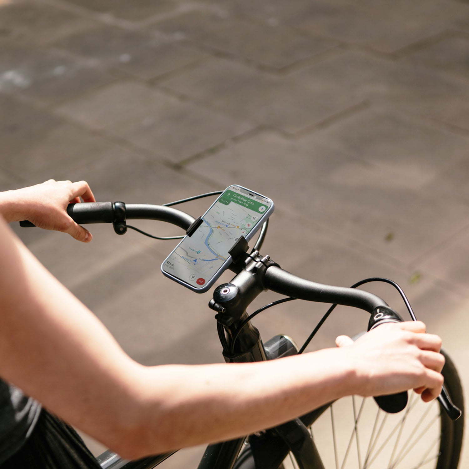 ZEITBIKE Loop Mount universal bicycle phone mount attached to handlebars, holding a smartphone during a ride.