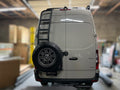 Avatar Offroad rear ladder tire carrier mount attached to van for secure spare tire storage on vehicle rear.