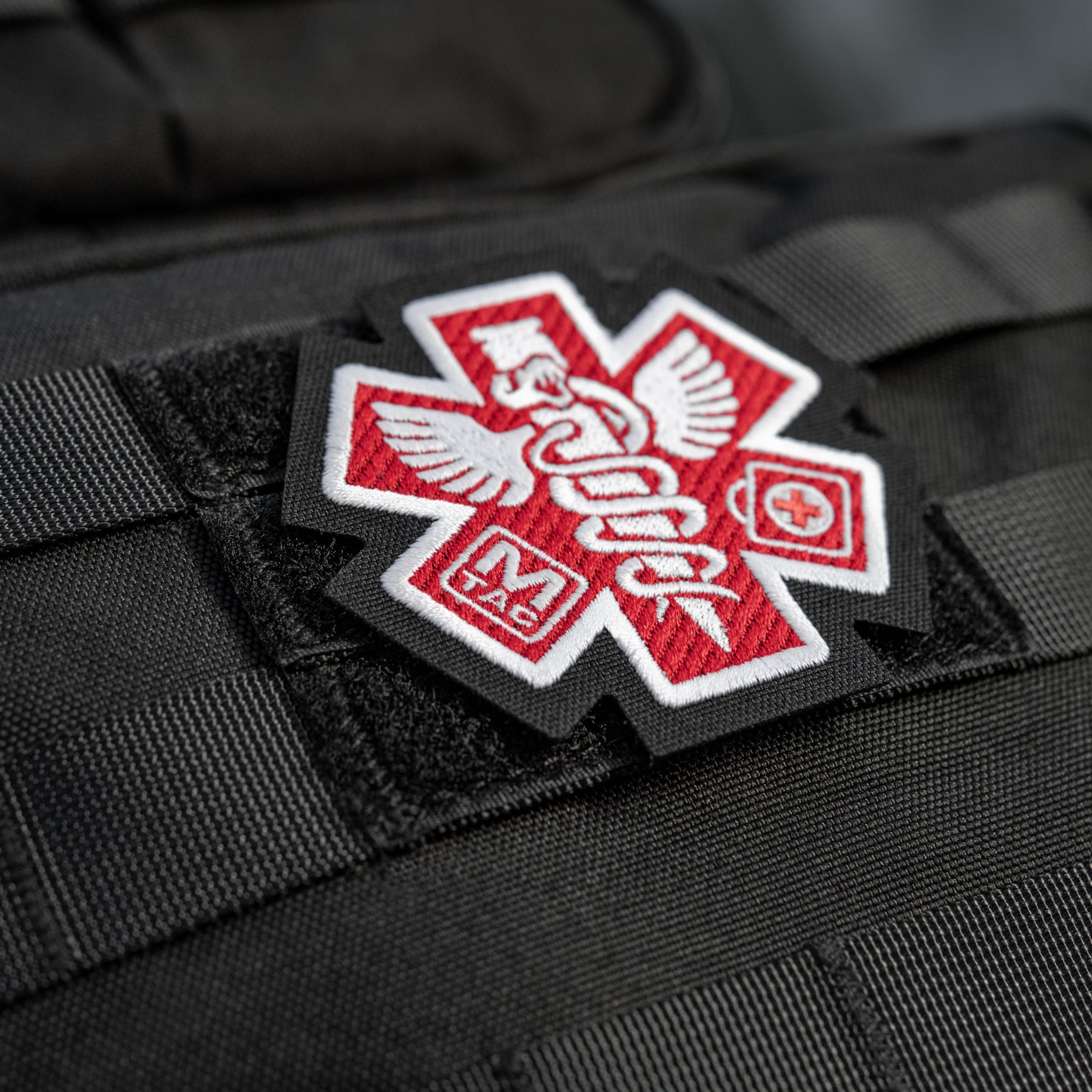 M-Tac Paramedic embroidered patch with a black background and red cross symbol, ideal for uniforms and gear.