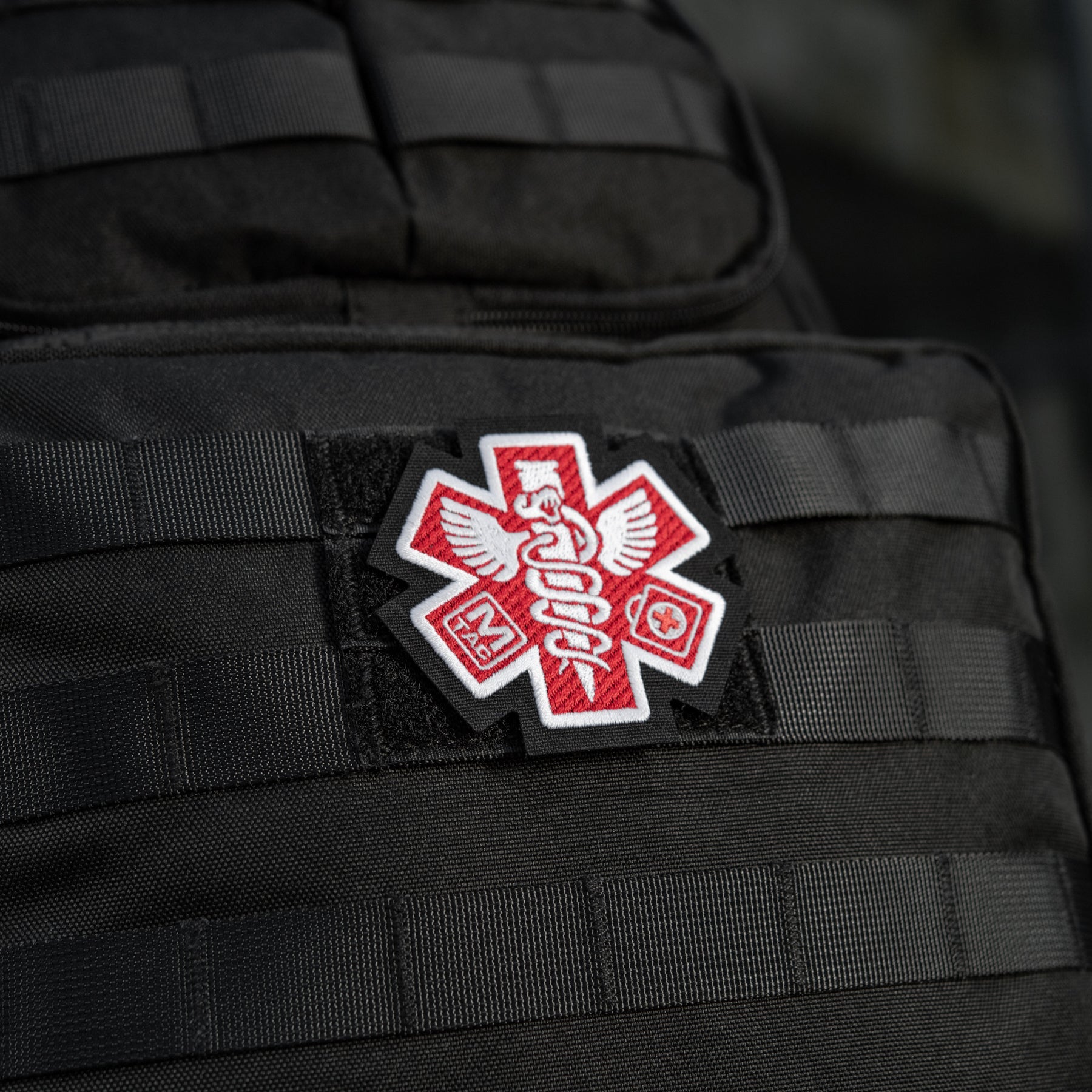M-Tac Paramedic embroidered patch featuring a black design with medical symbol for tactical gear or uniforms.