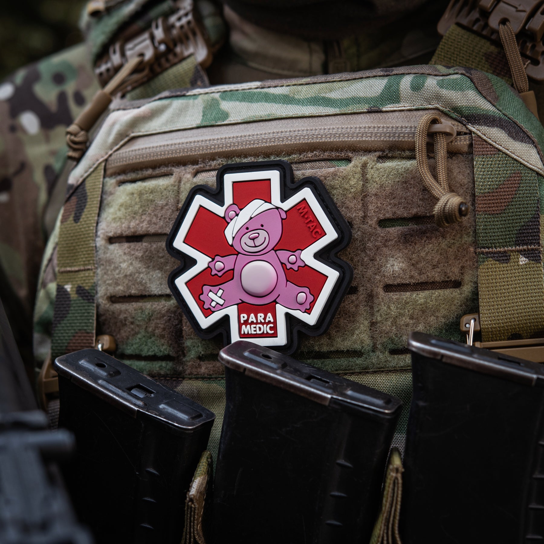 Embroidered M-Tac Paramedic Bear patch in pink and black, showcasing detailed bear design on fabric background.