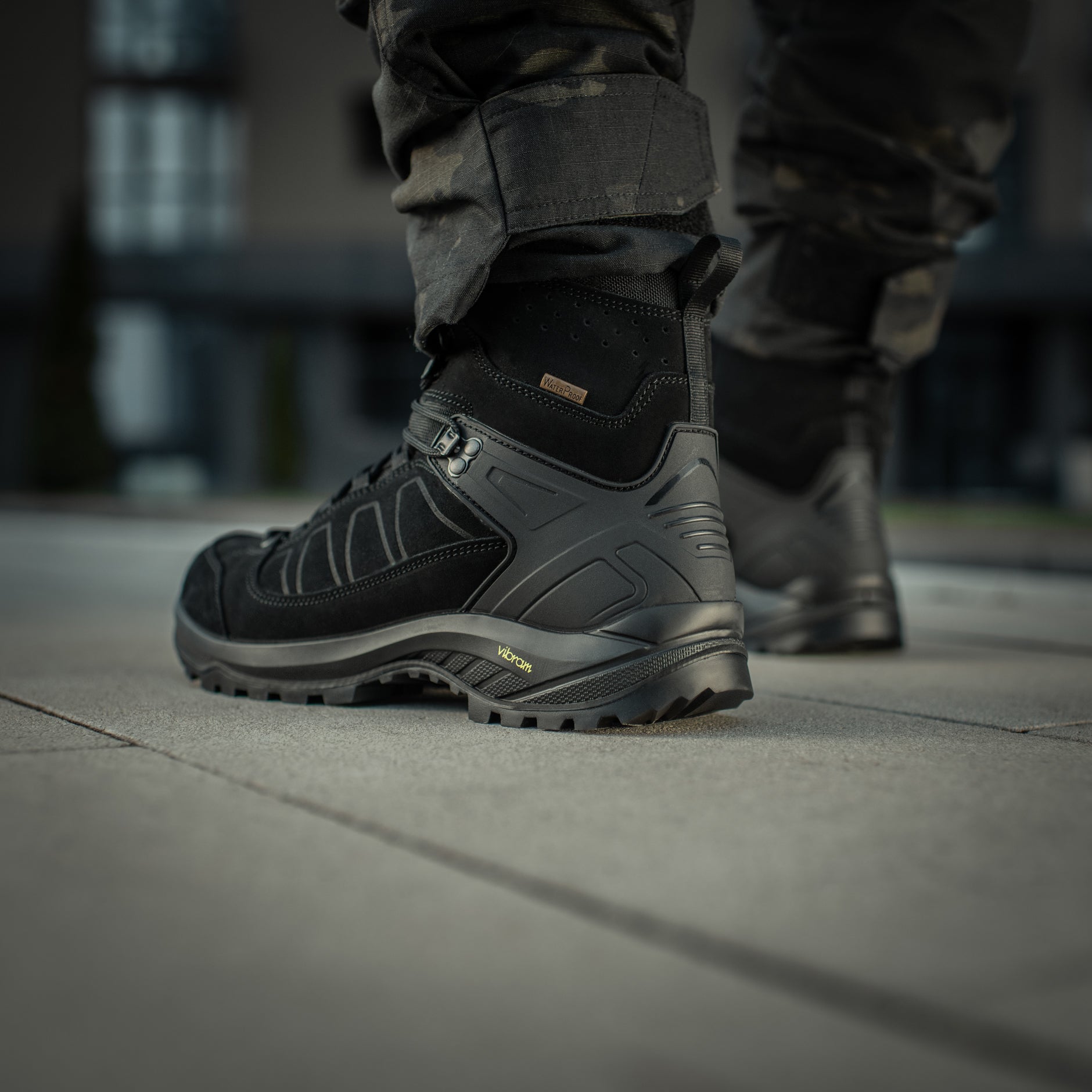 Black M-Tac tactical winter boots with rugged soles and reinforced ankle support, designed for cold-weather tactical use.