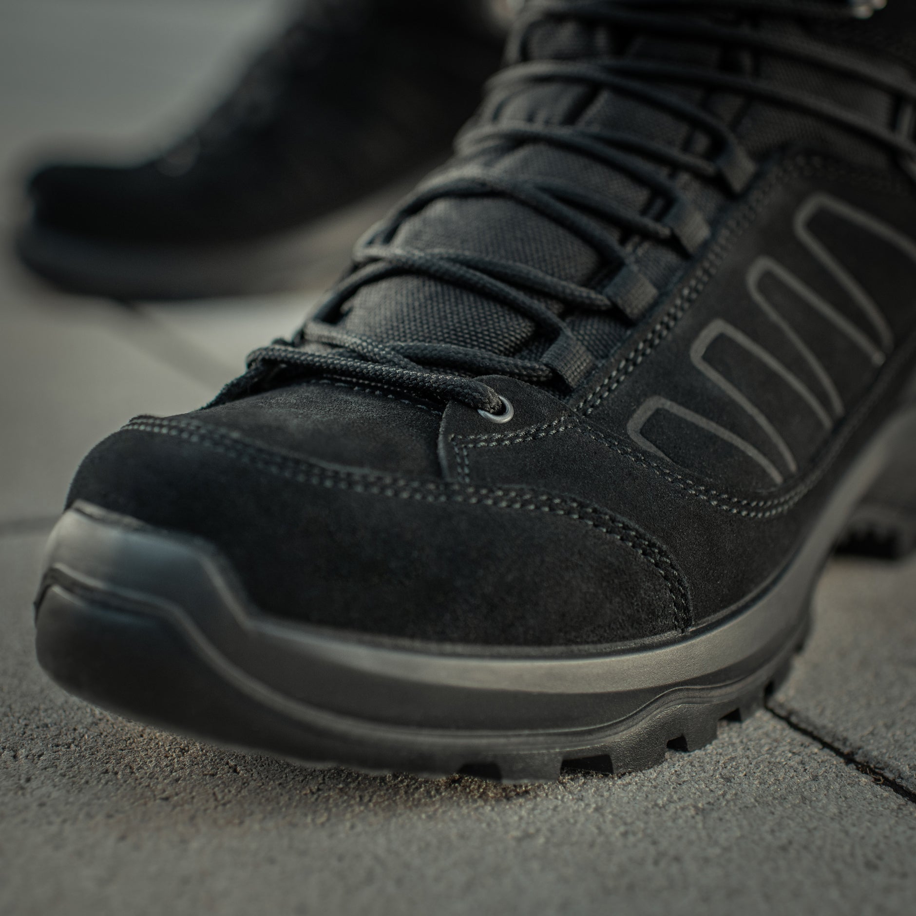 Black M-Tac tactical winter boots with rugged soles and ankle support, designed for outdoor and tactical use.
