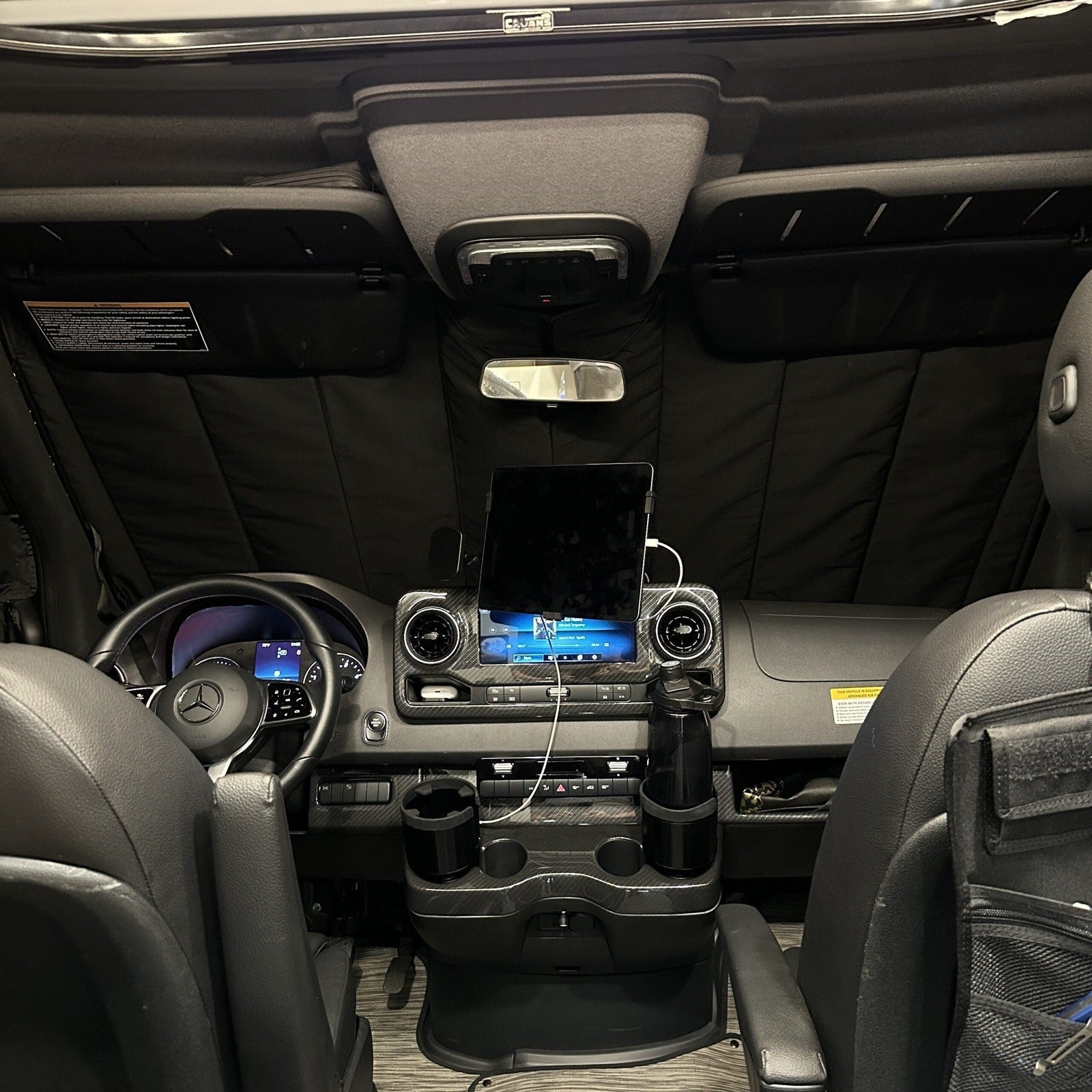 Canyon Adventure Vans CLIMA-SHADE™ insulated front windshield cover on vehicle windshield in outdoor setting.