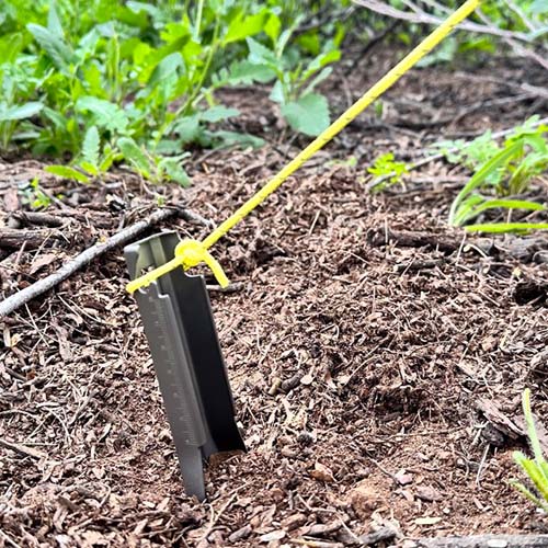 Near Zero Outdoor Gear titanium digging trowel, a lightweight and durable gardening accessory with a pointed blade for easy soil digging.