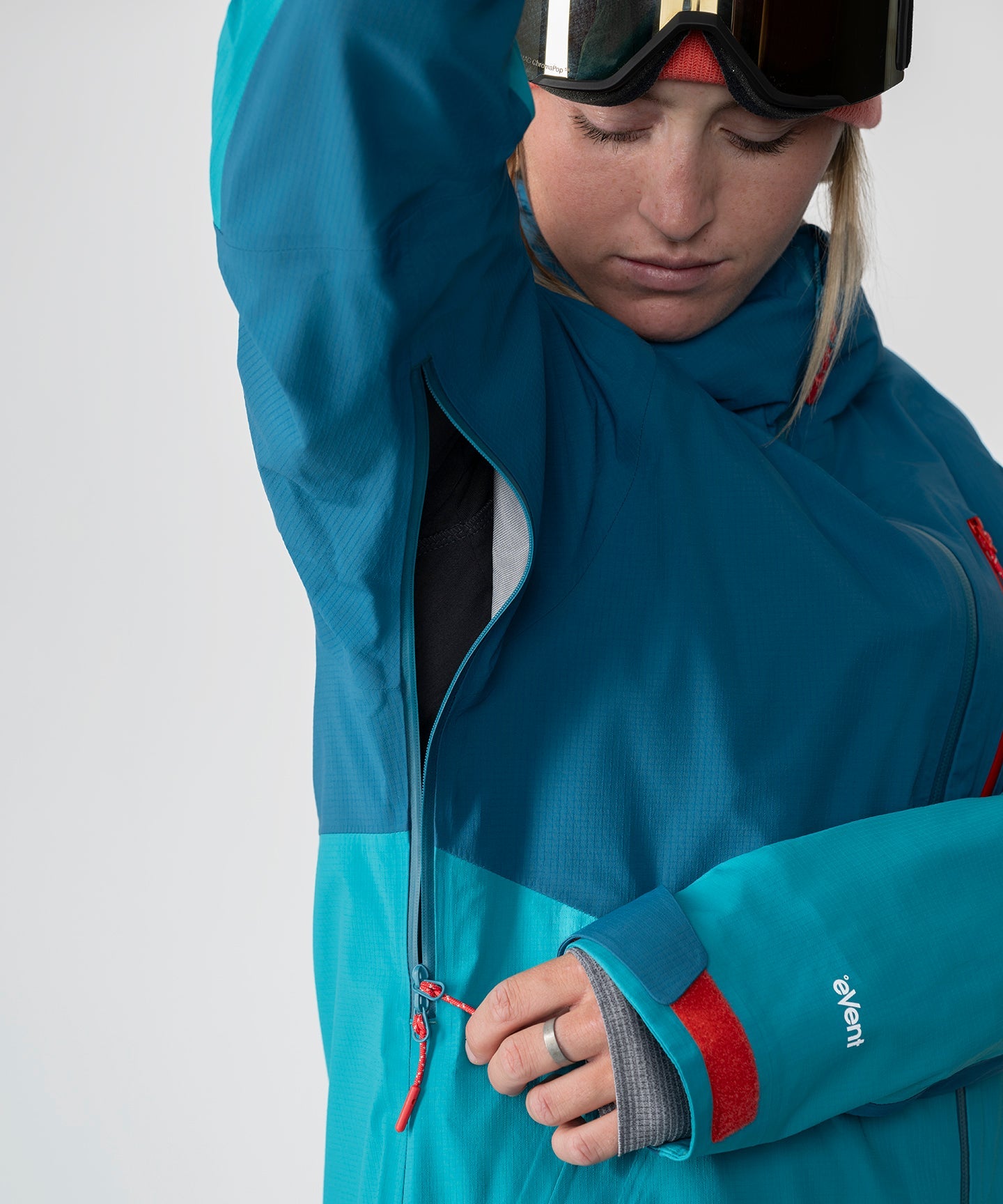 Dark teal Strafe Outerwear Meadow 3L shell jacket displayed on a hanger with visible hood and zippers.