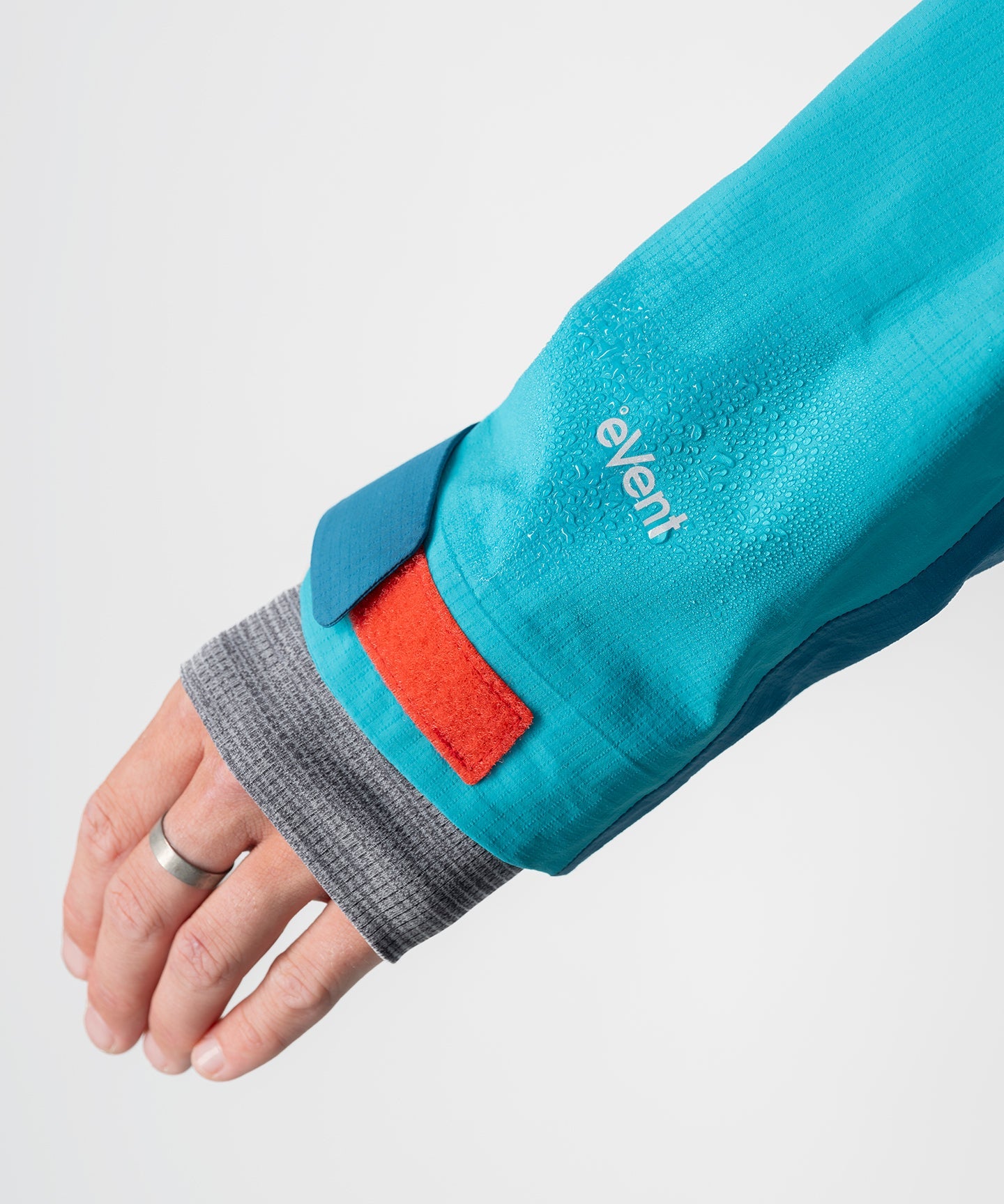 Dark teal Strafe Outerwear Meadow 3L shell jacket with adjustable hood and zippered pockets on display.