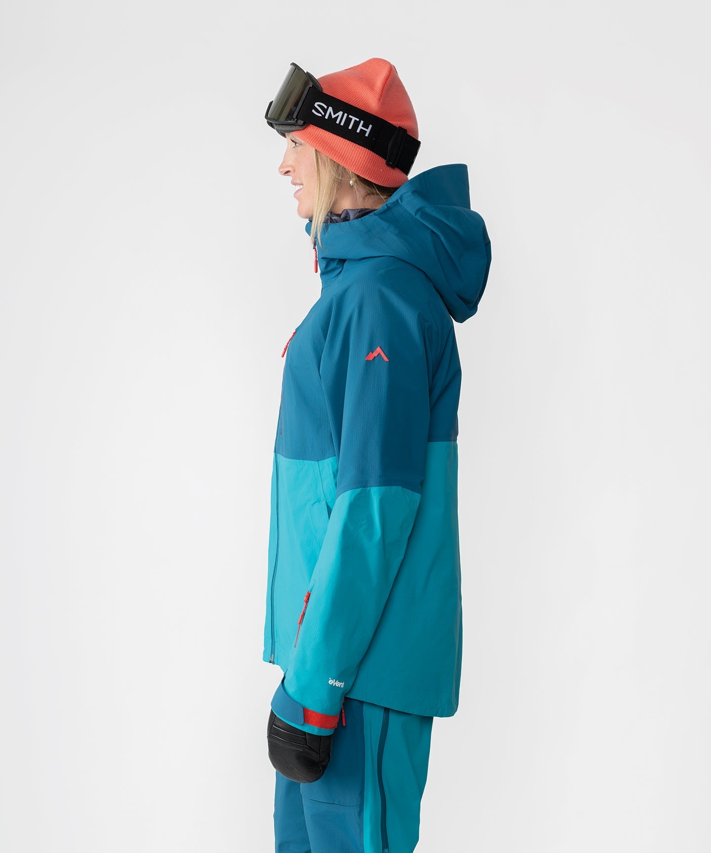 Dark teal Strafe Outerwear Meadow 3L shell jacket with a hood and zip pockets, designed for outdoor activities.