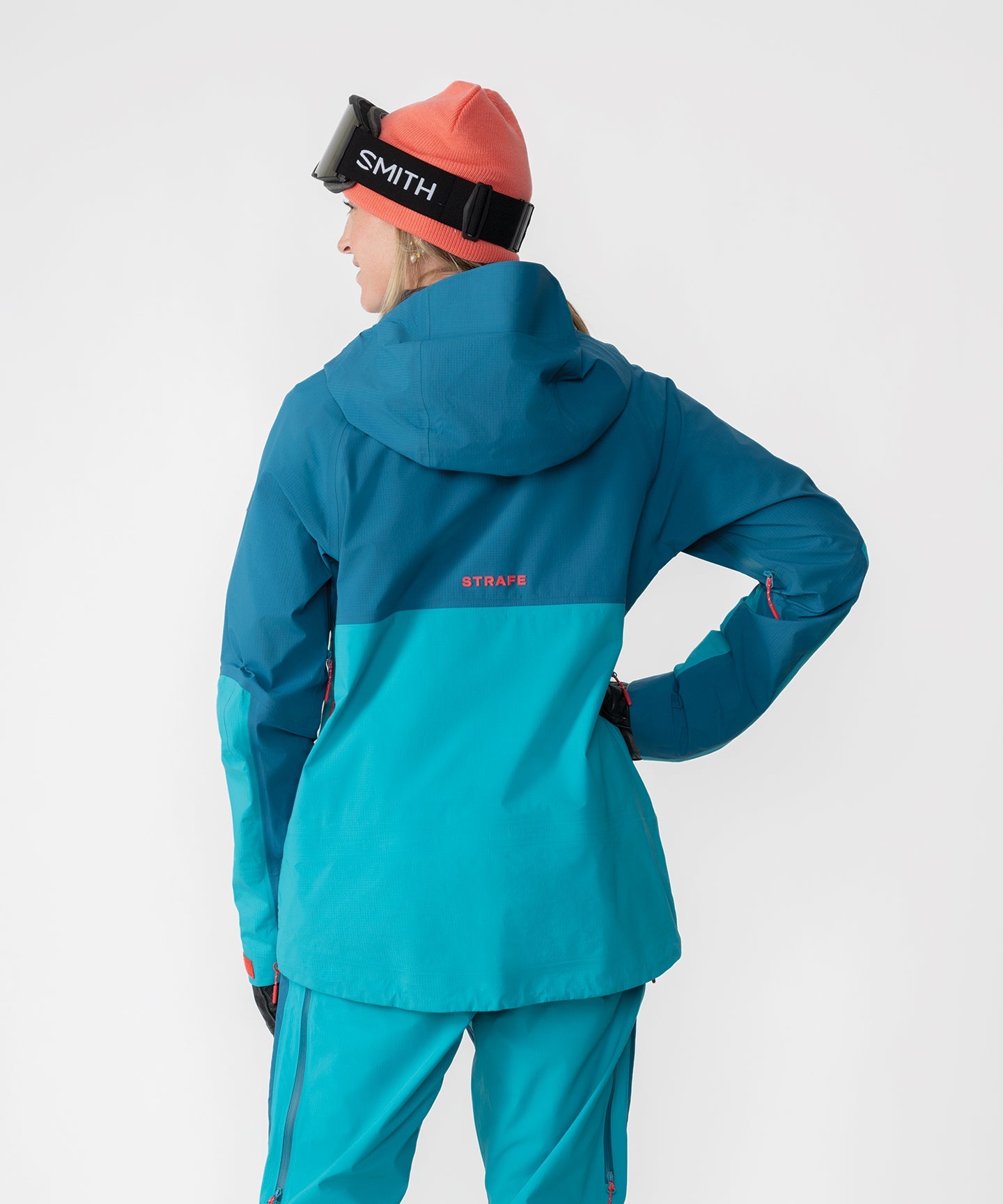 Dark teal Strafe Outerwear Meadow 3L shell jacket displayed with adjustable hood and zippered pockets.