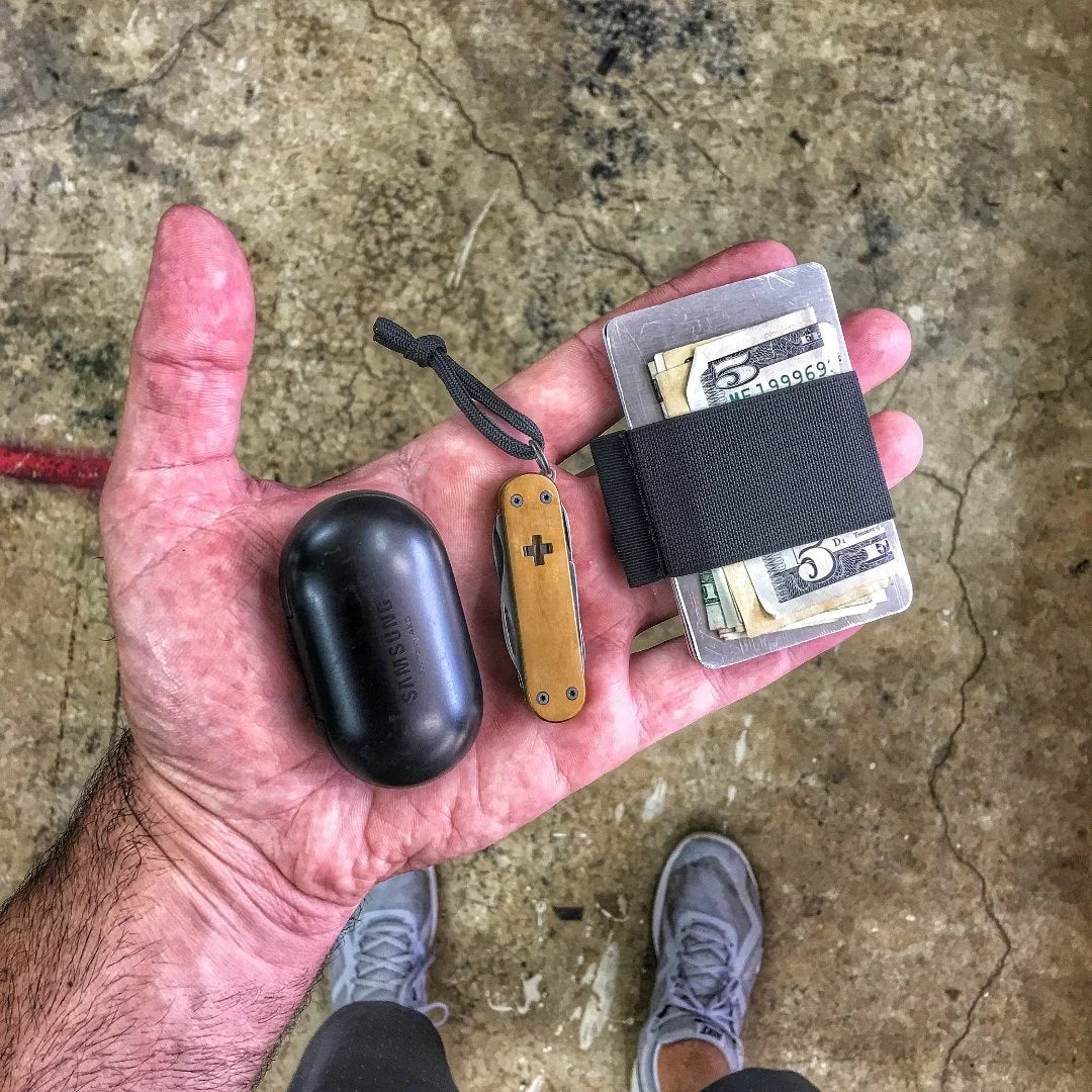 Black minimalist elastic card band wallet by Recycled Firefighter, featuring a sleek, slim design with a durable elastic strap.