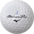 Mizuno Pro X golf ball with sleek white design, branded with Mizuno logo, resting on a golf course grass.
