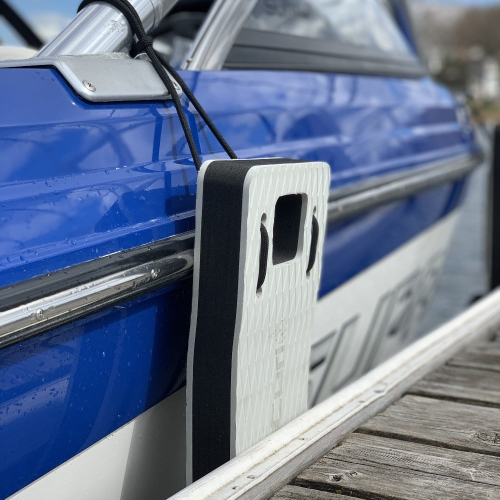 NautiFender flat boat fender by NautiCurl LLC, showing a cylindrical inflatable boat bumper in navy blue for vessel protection.