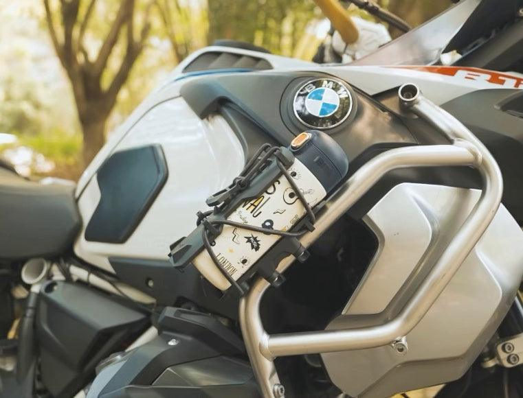 Motorcycle water bottle fire extinguisher holder by Bean's Moto Booth, designed for motorcycle accessories, mounted on a bike.