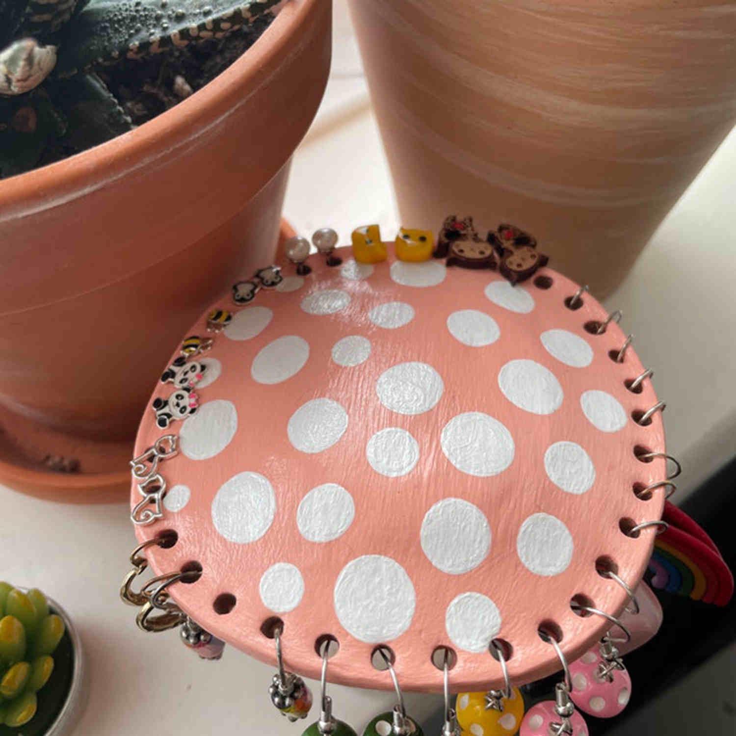 Bean's Moto Booth mushroom earring stand displaying multiple earrings on a wooden display with a mushroom shape.