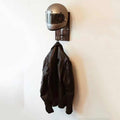 Bean's Moto Booth motorcycle helmet stand holding a helmet, black metal design, compact and sturdy for safe storage.
