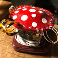 Bean's Moto Booth mushroom earring stands for organizing jewelry, featuring whimsical mushroom designs on a wooden display.