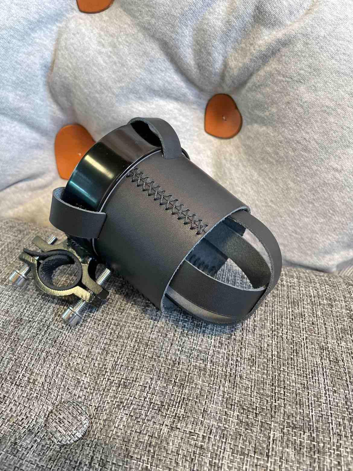 Handmade leather motorcycle water bottle holder from Bean's Moto Booth, designed as a durable motorcycle accessory for riders.