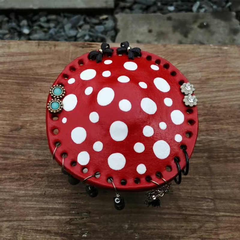 Bean's Moto Booth mushroom earring stands with wooden bases and colorful mushroom-shaped holders for jewelry display.
