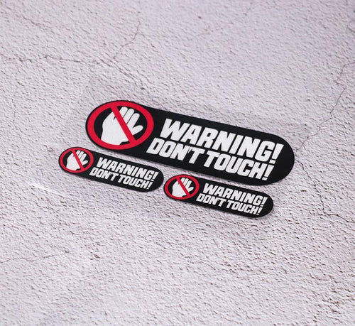 Decorative 3-inch "WARNING DON’T TOUCH" sticker by Bean's Moto Booth, featuring bold warning text on a clear background.