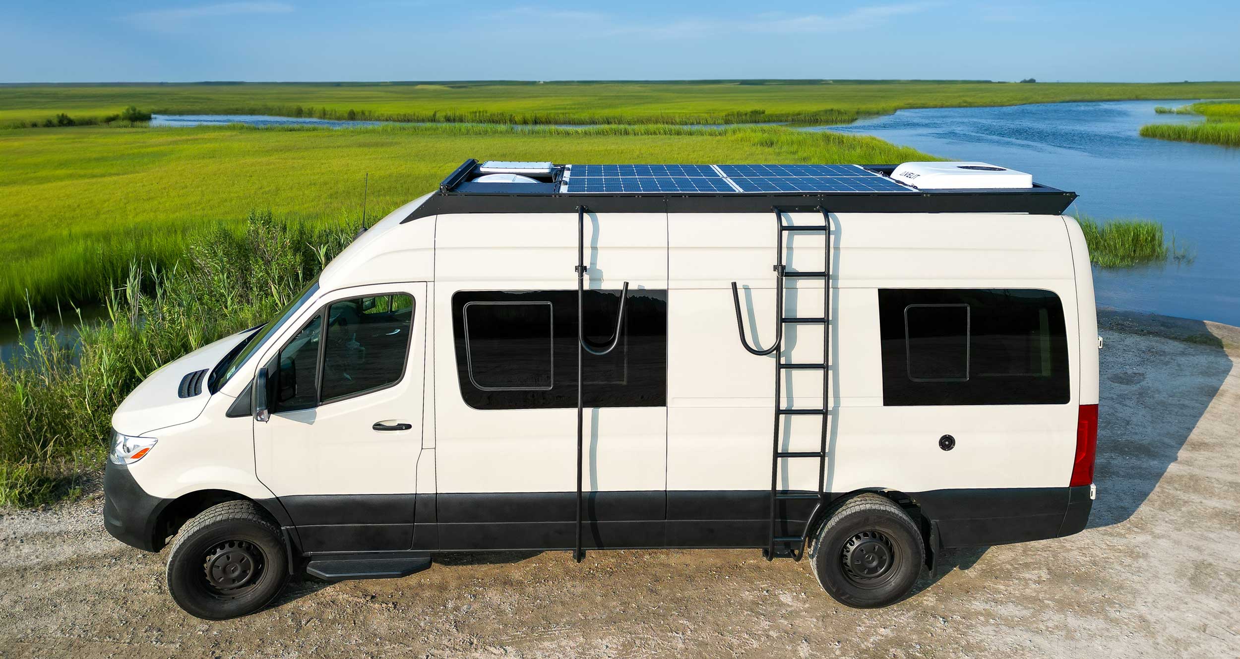 Sprinter Wheel Wrap Side Ladder mounted on roof rack with solar panel and Starlink antenna, by Orion Van Gear.