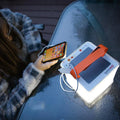Alpenglow Readiness Supply PackLite Titan 2-in-1 Power Lantern with smartphone plugged in, showcasing outdoor use.