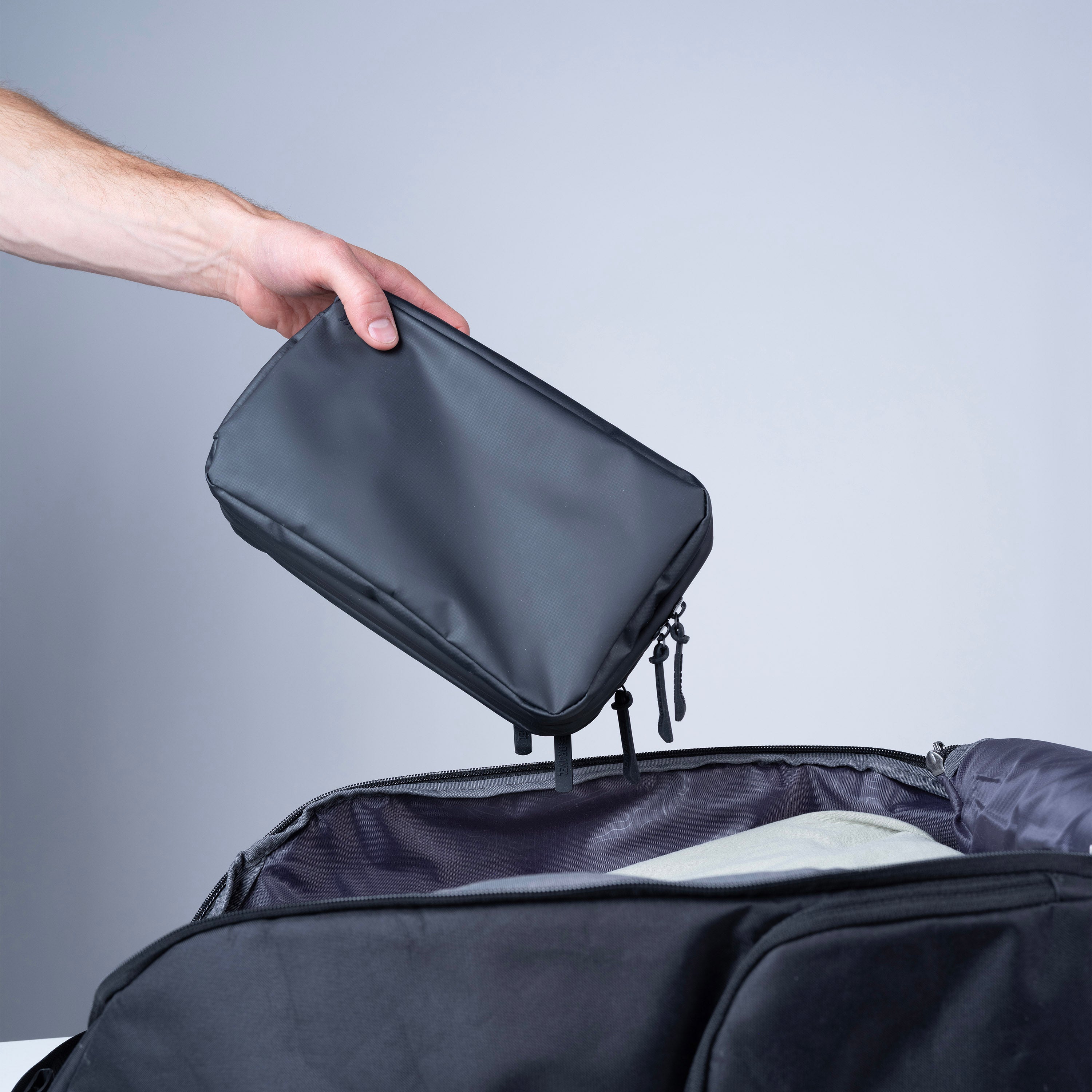 Gravel Plus™ Toiletry Bag with multiple compartments and zipper closure, designed for travel organization.