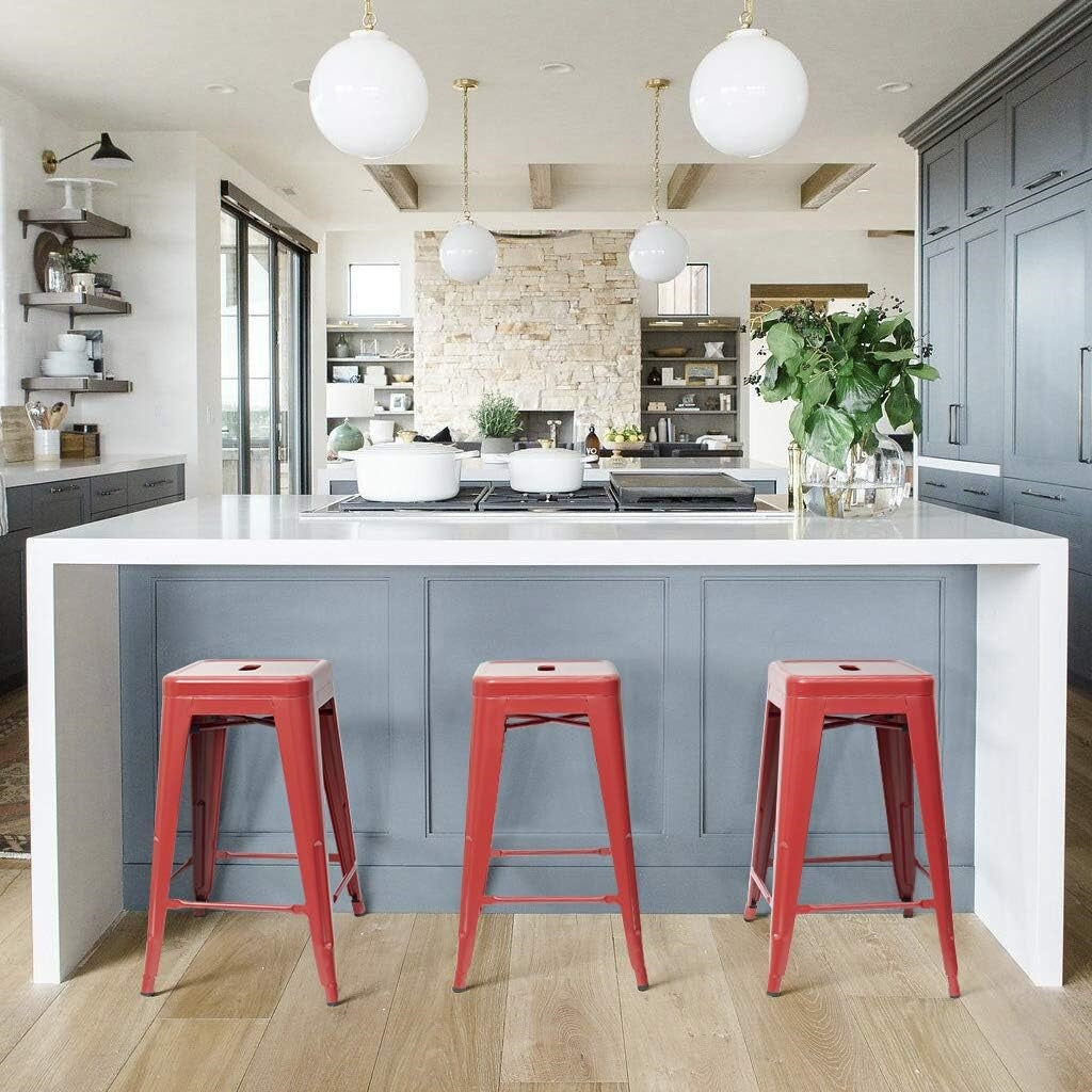 Set of four red metal backless stacking indoor/outdoor barstools with 24-inch height, suitable for dining or bar areas.