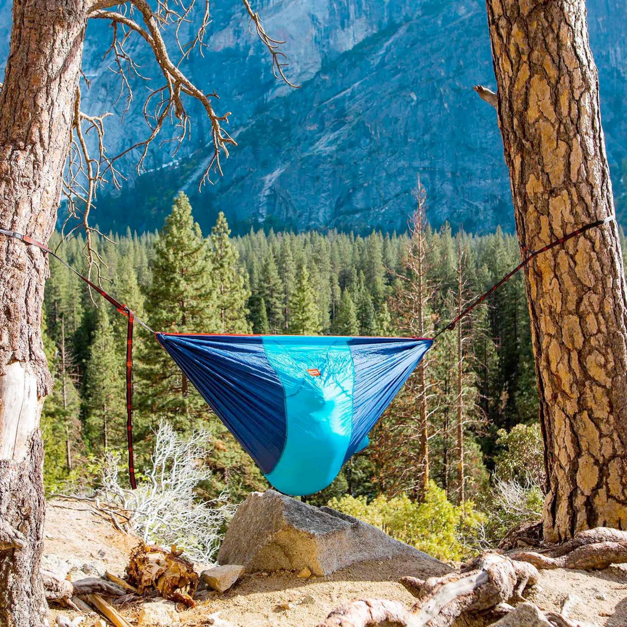 GrandTrunk ROVR™ Hanging Chair, a cozy hammock designed for relaxation, suspended outdoors with vibrant colors and a sturdy frame.