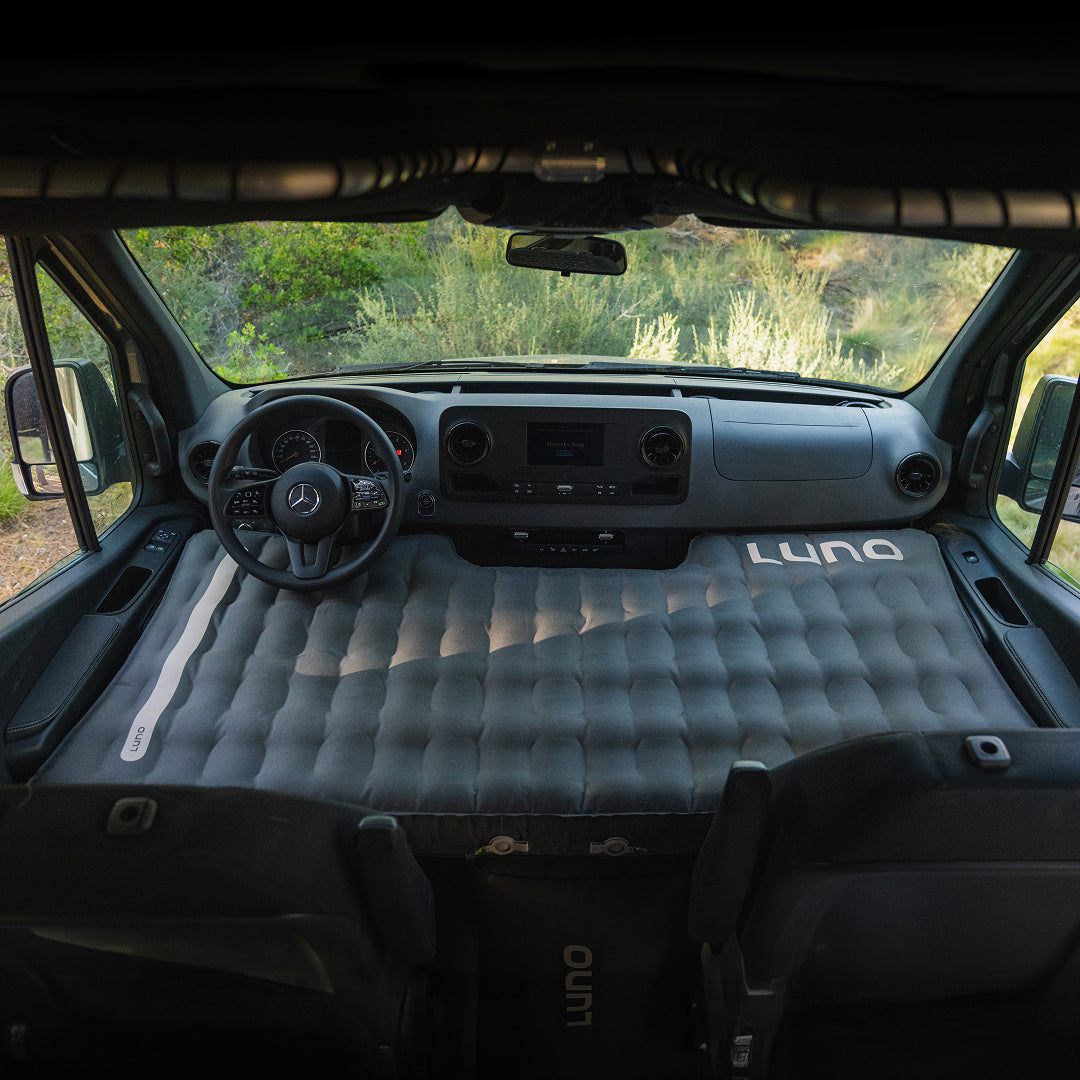 Inflatable mattress in the back of a vehicle with 'Luno' branding 
