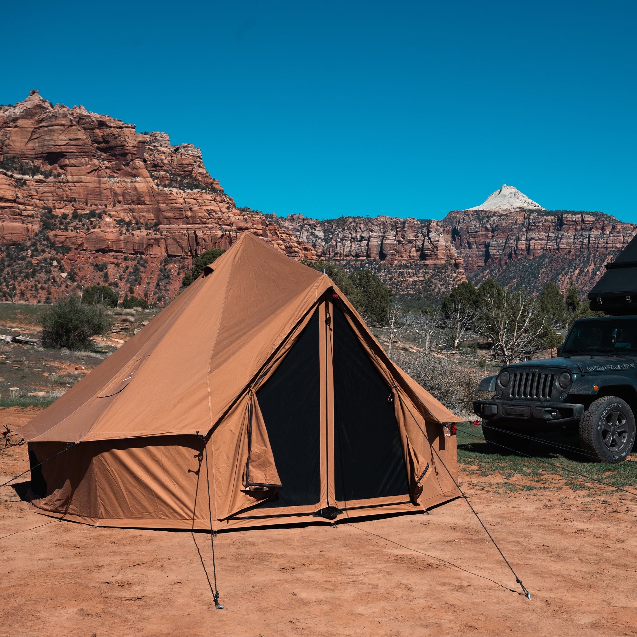 White Duck Outdoors Regatta Bell Tent in sandstone beige set up outdoors with a car parked nearby.