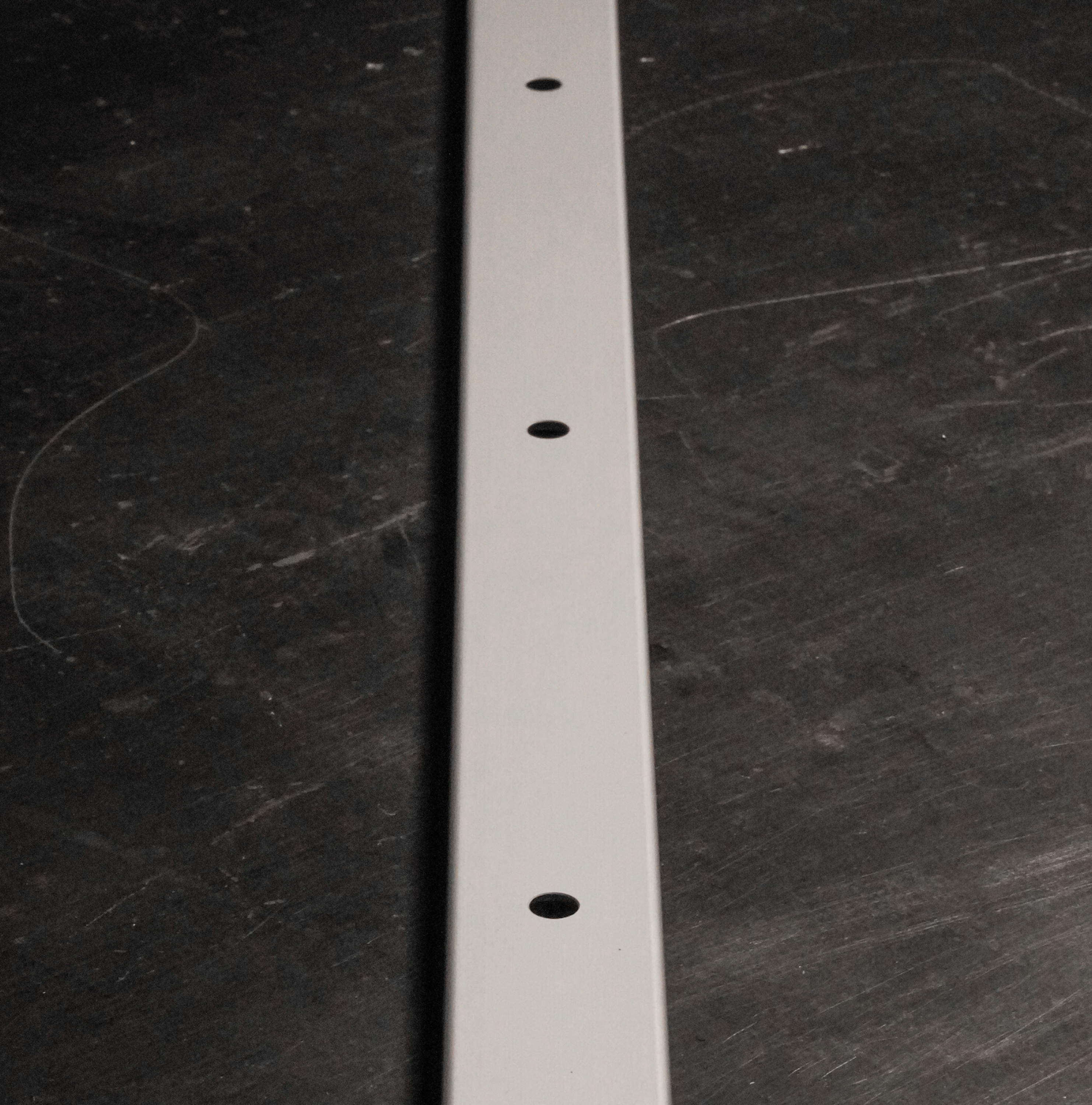 Pair of Rollercam L Track surface mount brackets for truck bed installation, shown in black with mounting hardware.