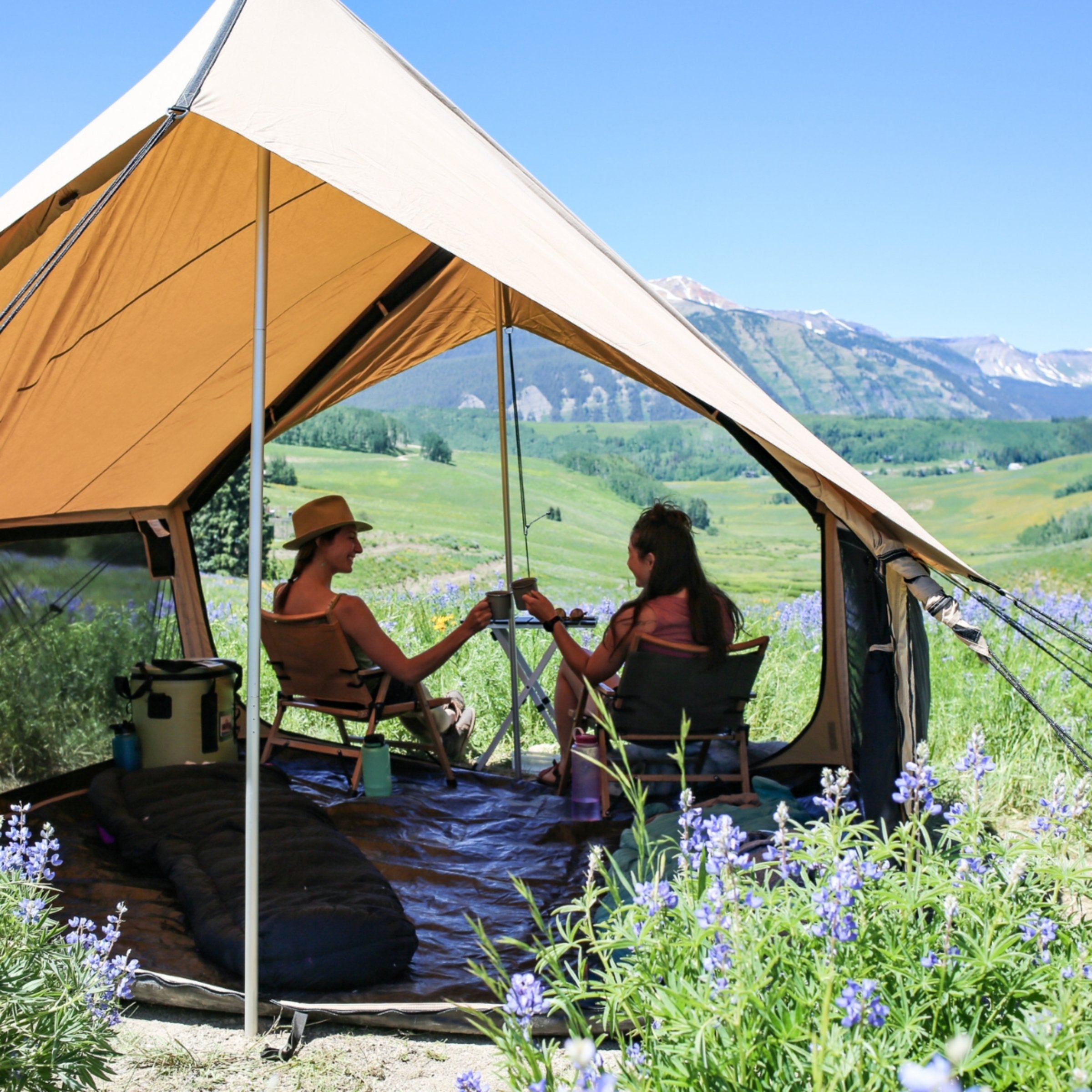 Beige Rover Scout Tent by White Duck Outdoors fully open with a couple camping outside in a natural setting.