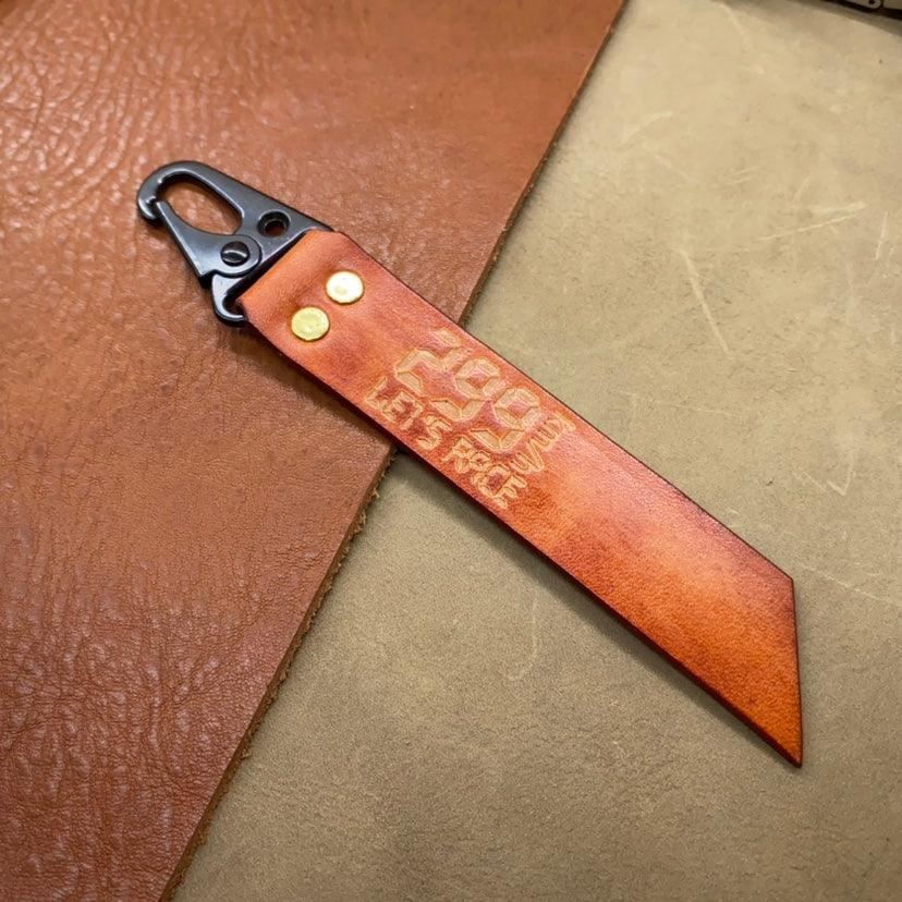 Leather motorcycle keychain with "299KM/h" top speed design, handmade decor by Bean's Moto Booth.
