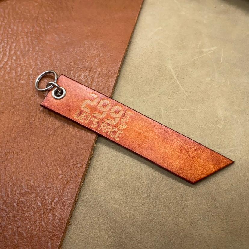 Leather motorcycle keychain with "299KM/h" top-speed design, handmade decor from Bean's Moto Booth, detailed close-up image.