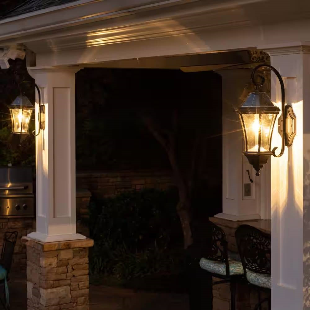 Black outdoor farmhouse solar wall light by HomePacific, illuminating with 150 lumens in a rustic outdoor setting.