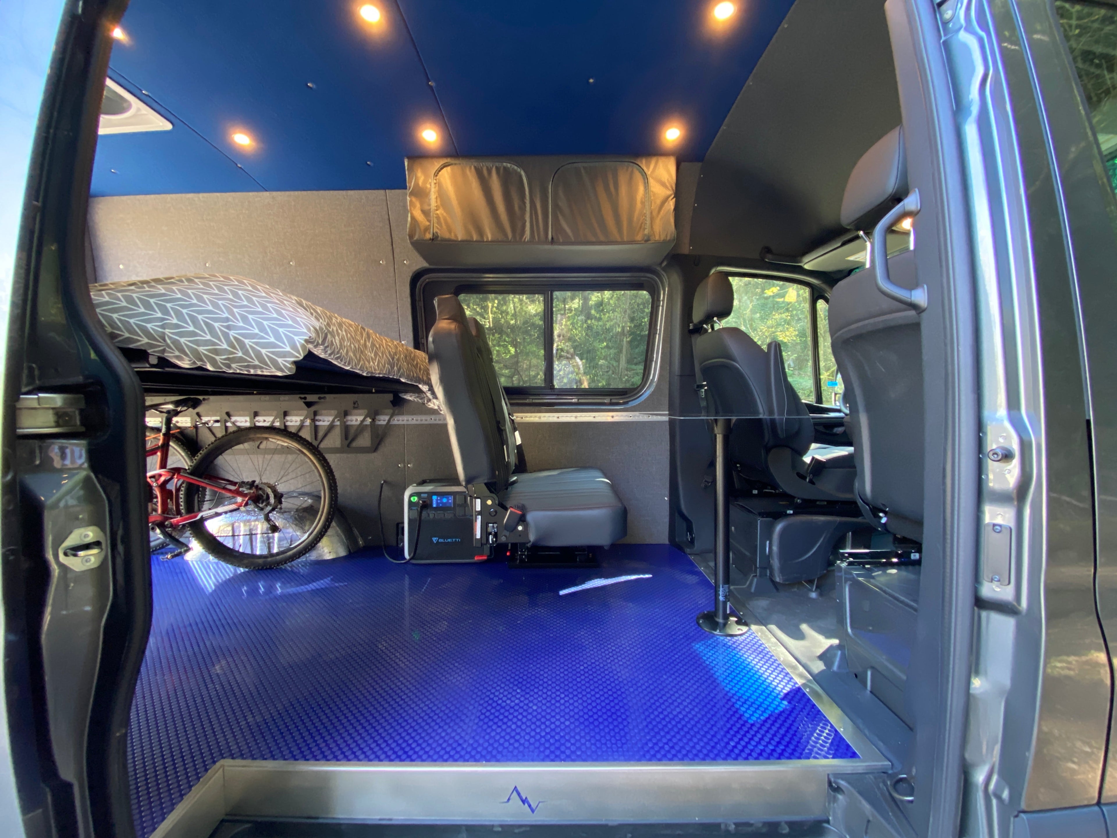 Insulated Sprinter floor kit from Alpine Van Works installed inside a van with visible flooring and slider door.