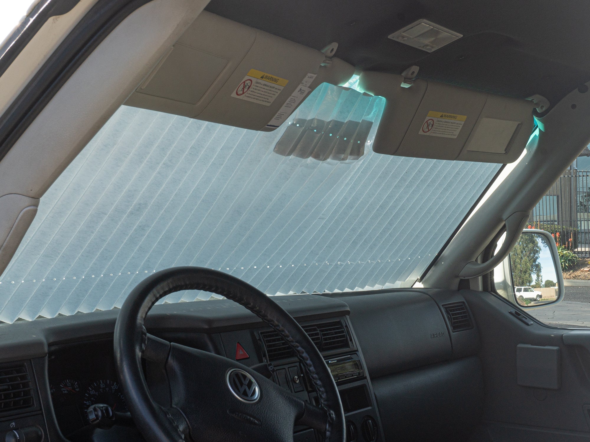 GoWesty retracting sun and privacy shade installed inside a Vanagon, providing shade and privacy for bus and Eurovan windows.