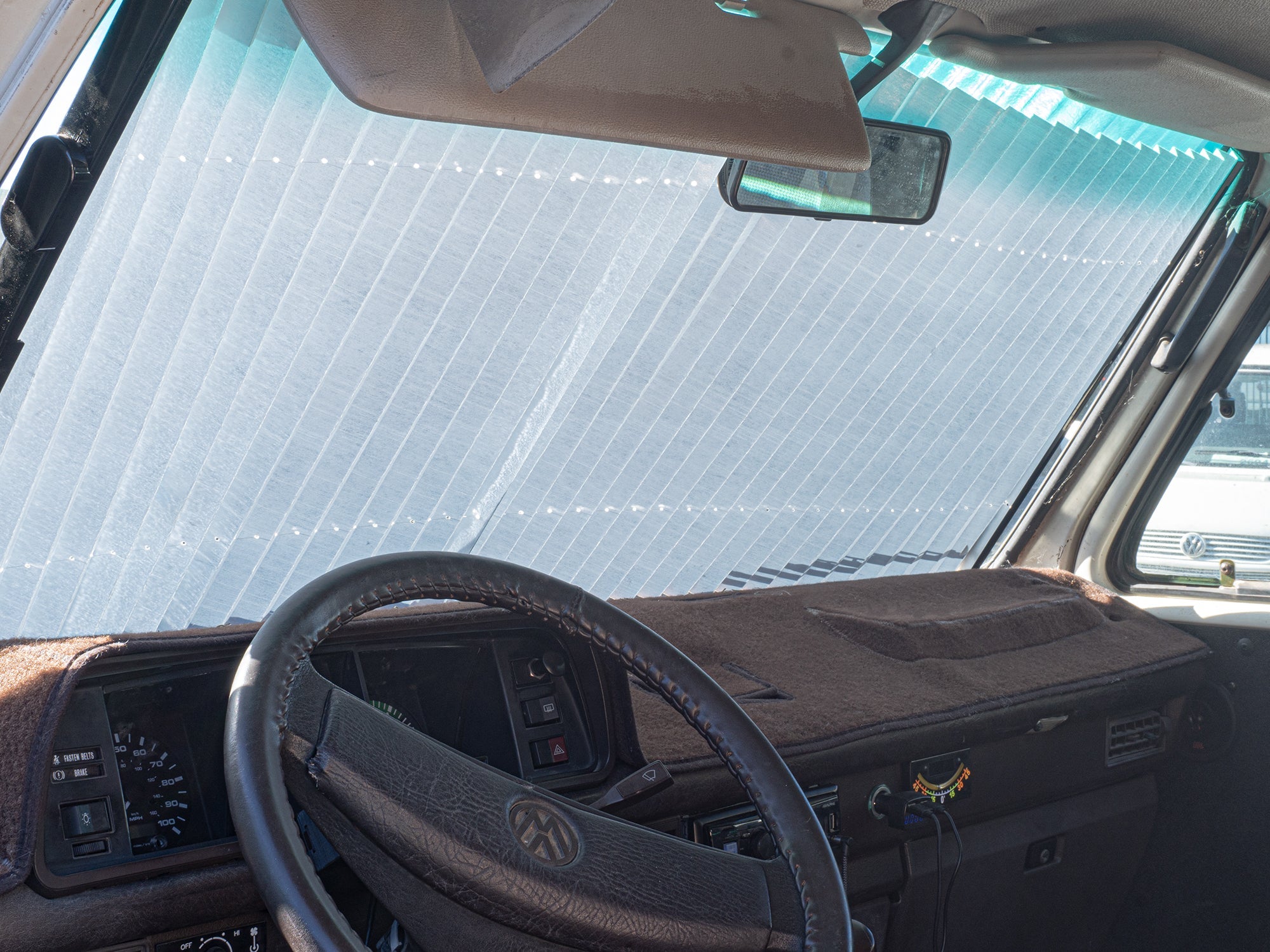 GoWesty retracting sun and privacy shade installed on Vanagon windshield, providing shade and privacy for bus and Eurovan.