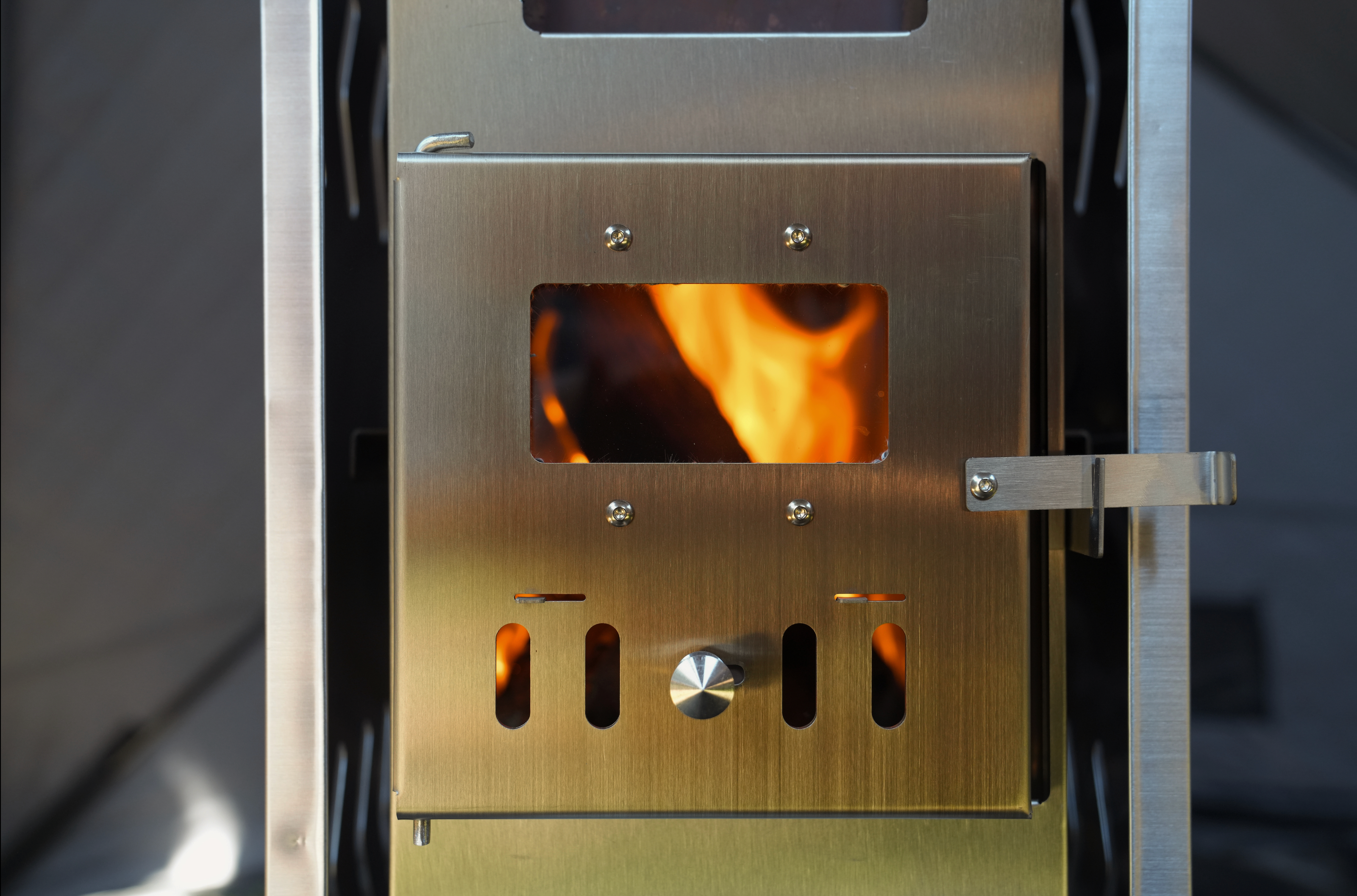 Portable North Shore Sauna tent wood stove in brushed stainless steel, showcasing its sleek design and compact size.