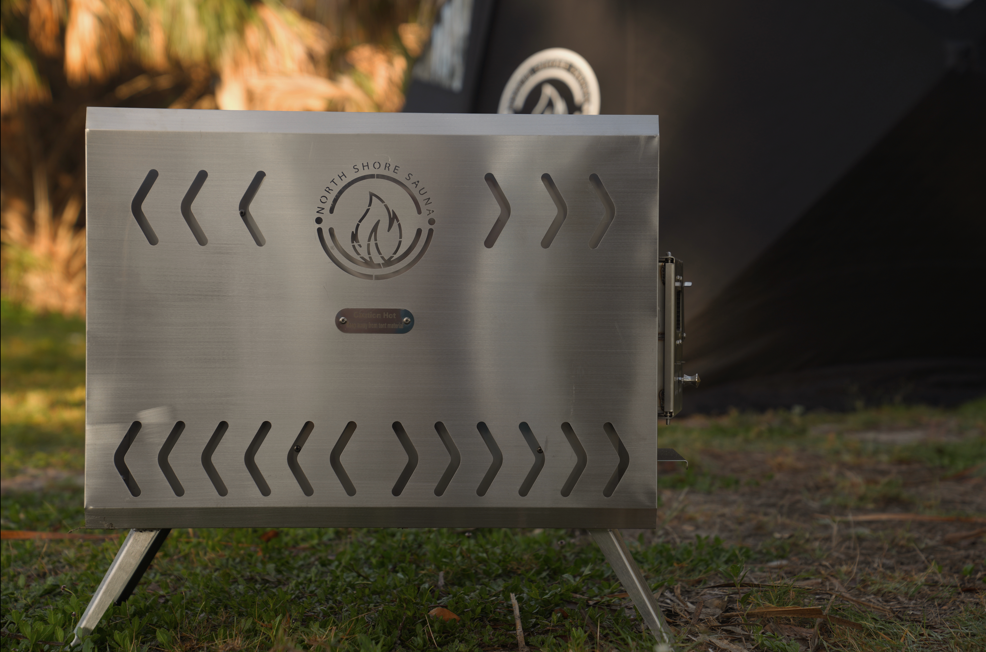 Portable North Shore Sauna tent wood stove in brushed stainless steel with a compact design for outdoor use.