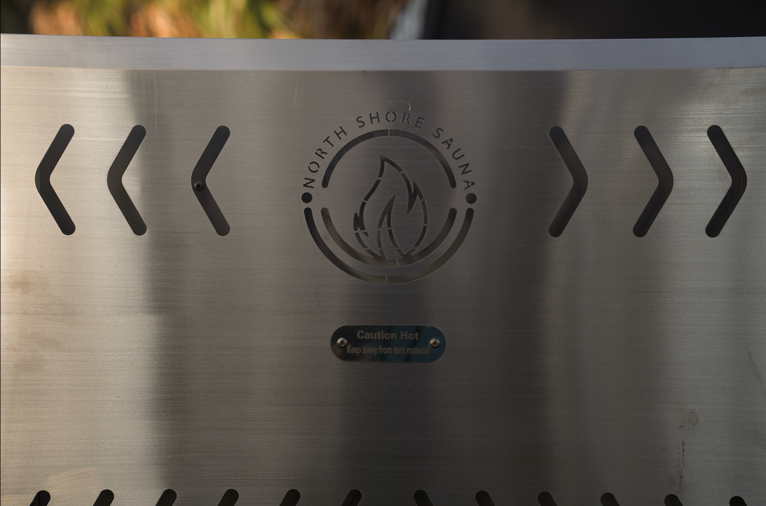 Portable North Shore Sauna tent wood stove in brushed stainless steel, designed for outdoor sauna use.