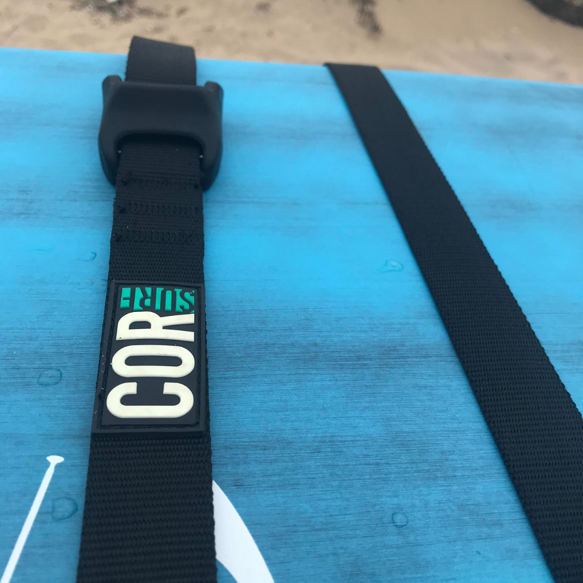Close-up of COR Surf scratch-resistant silicone tie-down strap, 15 ft, showing durable material and secure locking mechanism.