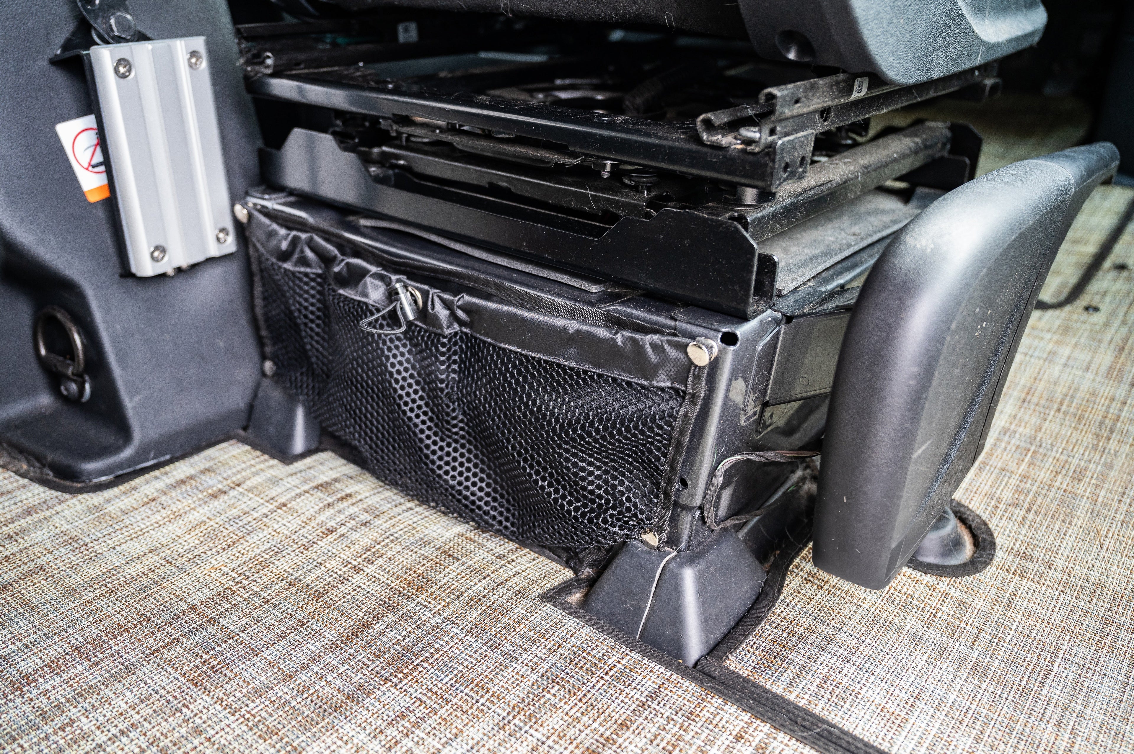 Alpine Van Works Sprinter seat base bags for storage solutions in a van interior, shown attached to vehicle seat bases.